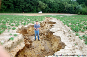Une grande faille (de la taille de l'agriculteur) due à l'érosion est apparue dans un champs